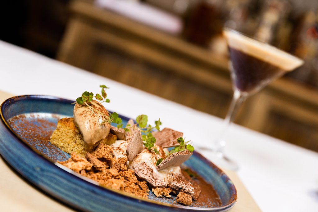 Dessertteller mit Espresso Martini im Hintergrund.